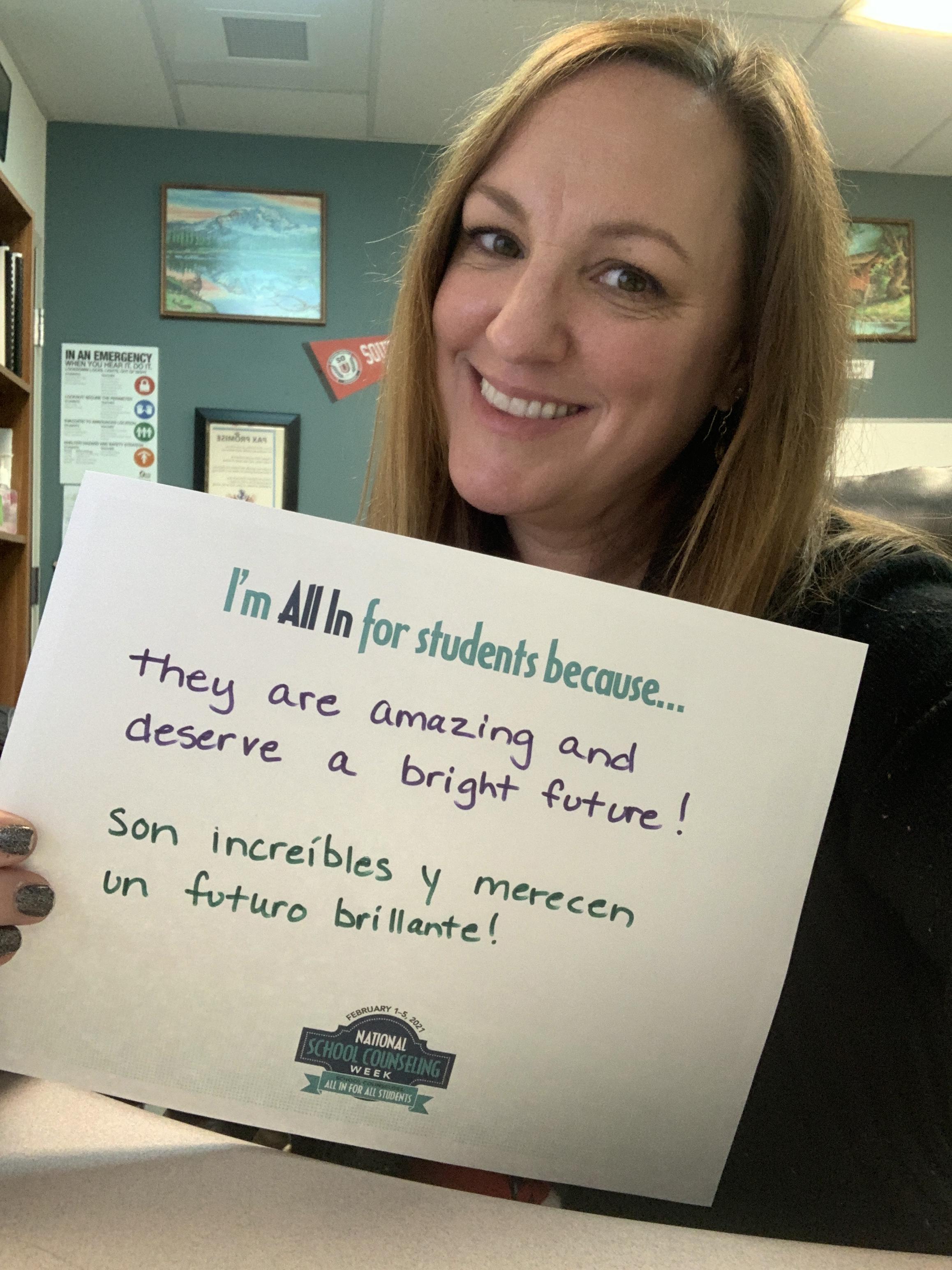 Jennifer Yankovich with a sign "I'm all in for students because they are amazing and deserve a bright future!"